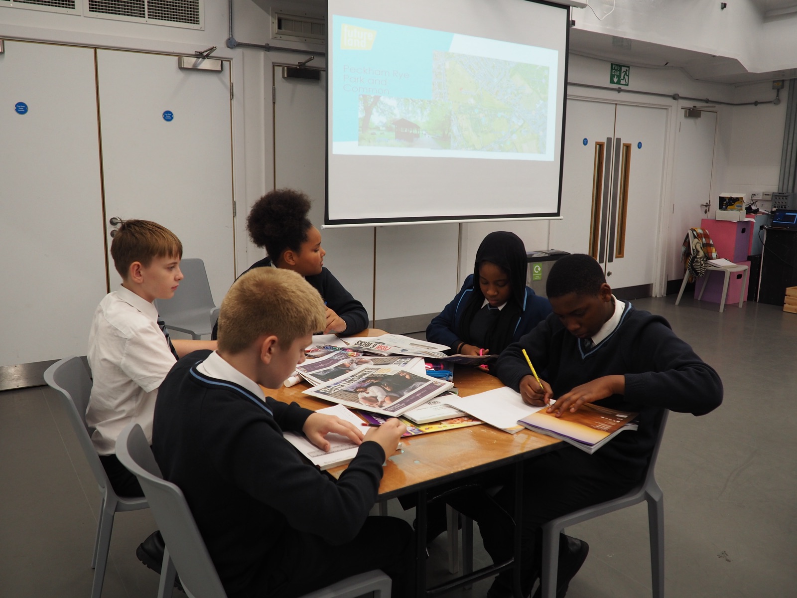 Young people writing and creating together around a workshop table