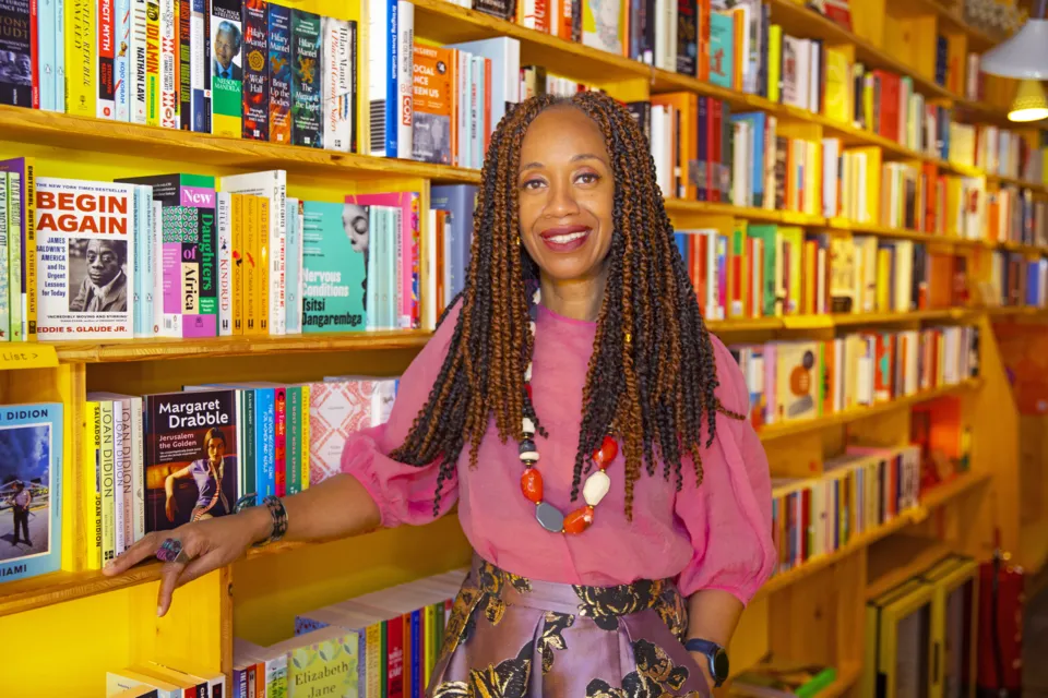 Joy Francis standing beside bookshelves